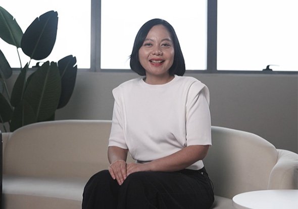 2026TravelRetail524245InterviewNadya Pamela seated on a sofa beside a black suitcase