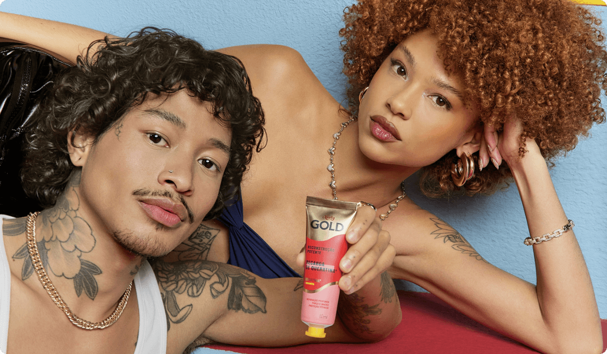 2025ConsumerProductDivisionNielybrandmanwomanwithcurlyhairtattoosmanholdinggoldenhaircolortubbe