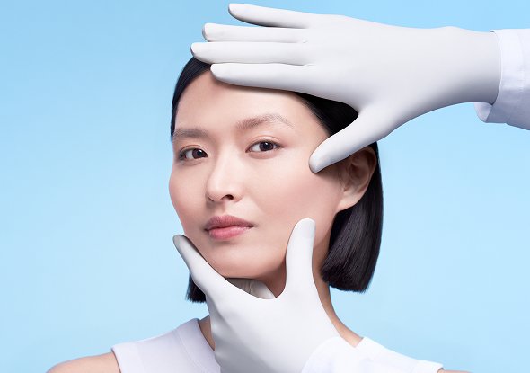 2026 dermatological beauty division white woman examining her face skin herobanner desktop