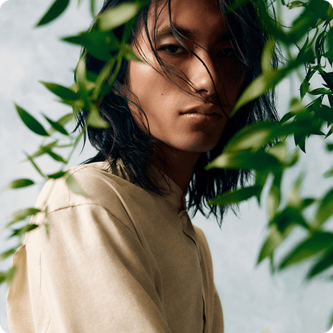 2025 loreal luxe brand atelier cologne man in beige shirt behind the green leaves