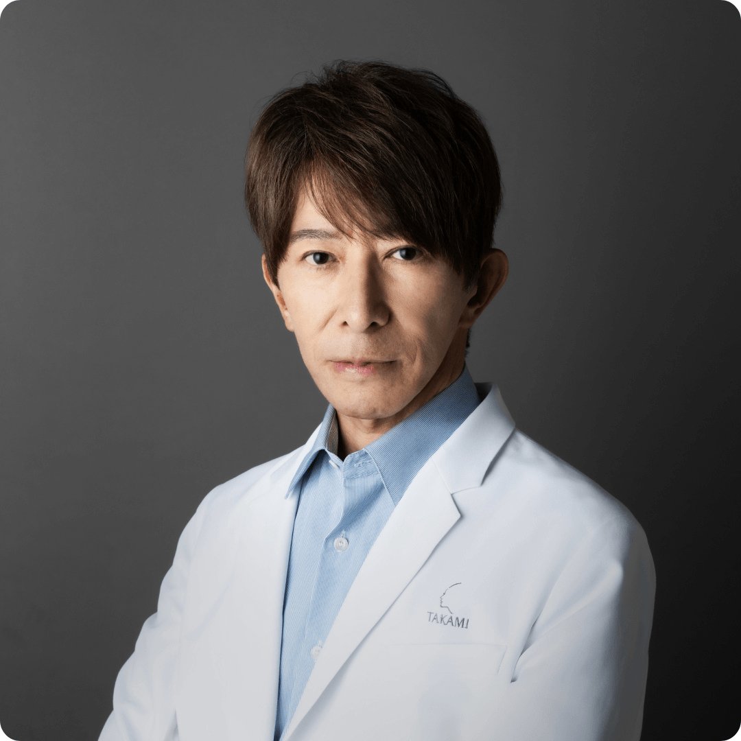 2026Takami000000PresidentManifestoDr Hiroshi Takami wearing white lab coat arms crossed dark grey b