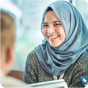 Eine Frau mit einem blauen Kopftuch lächelt