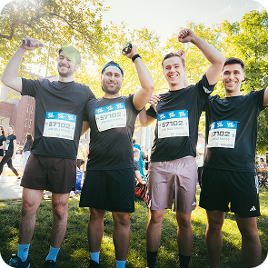 Eine Gruppe von männlichen L'oréal Mitarebeitern feiern ihren geschafften Marathonlauf in Düsseldorf