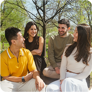 Vier Personen unterschiedlicher Herkunft sitzen zusammen und unterhalten sich