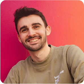 Portrait eines männlichen Praktikanten vor einem Rosa orangenen Hintergrund