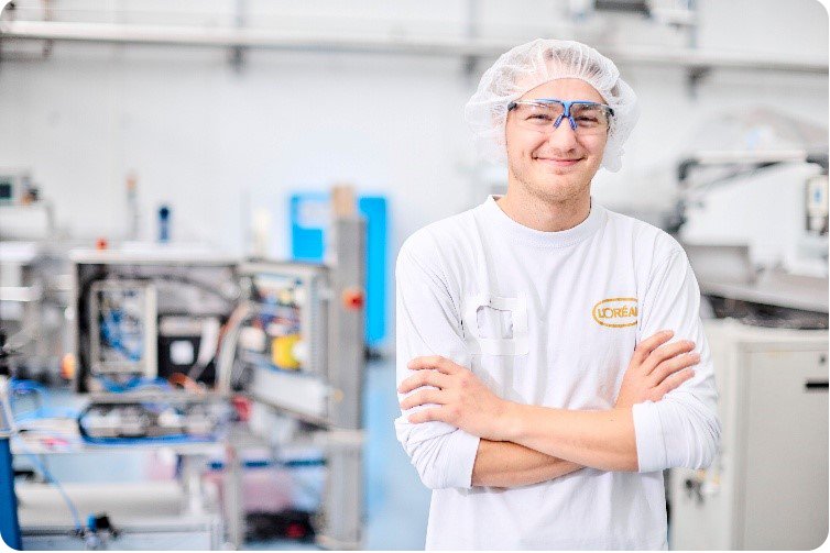 Ein junger Mann in Schutzkleidung in der L'Oreal Fabrik
