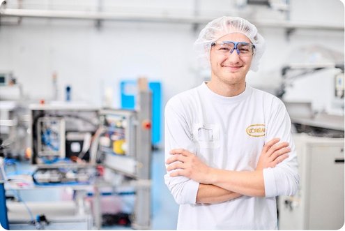 Ein junger Mann in Schutzkleidung in der L'Oreal Fabrik